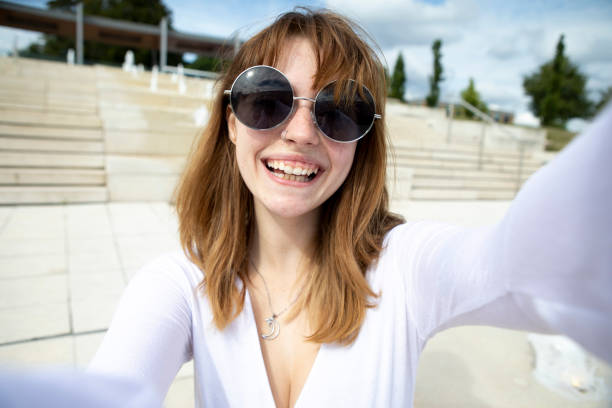istock One young woman with sunglasses taking a selfie, outdoors in summer 1340013122