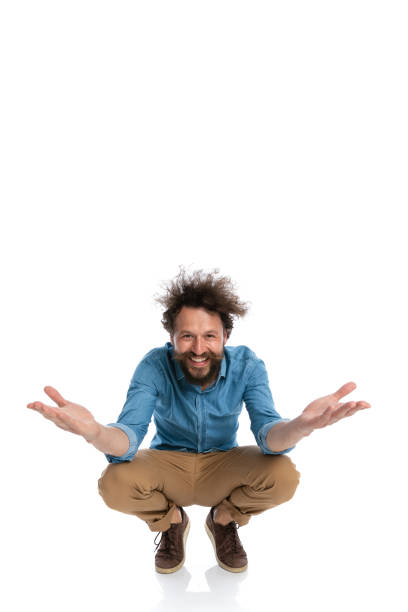 istock casual young man squatting with open arms 1340013484