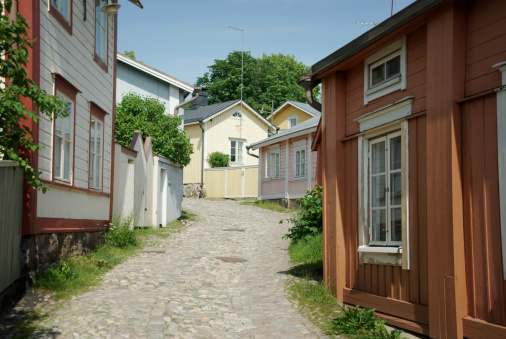 View of the old part of the city of Porvoo, Finland. Idyllic stone-paved street goes between traditional wooden residential houses.