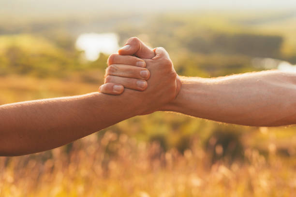 Two strong hands are holding one by another for help and cooperation. stock photo
