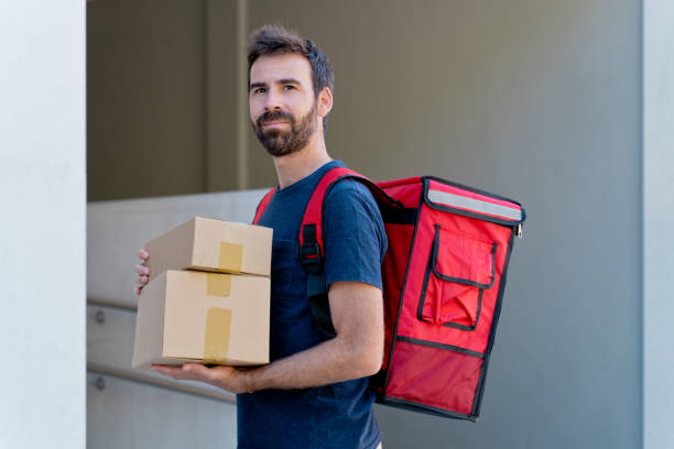 istock caucasian delivery man delivering parcel box. 1340015916