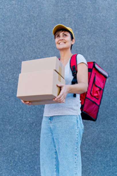 istock caucasian delivery woman delivering parcel box. 1340015934