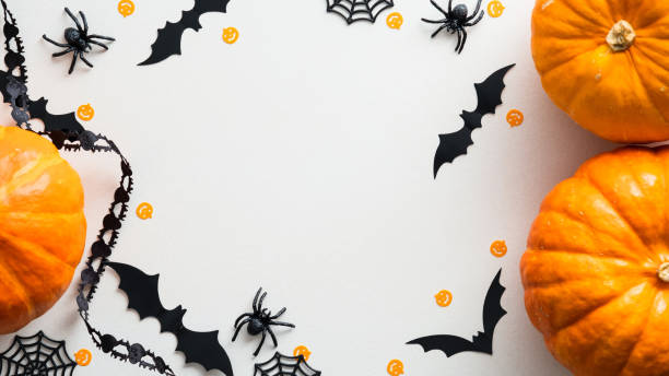 istock Happy Halloween holiday concept. Flat lay composition with pumpkins, bats, spiders on white background. Halloween decorations top view. 1340016826