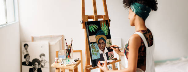 istock Young female painter working on a portrait painting in her studi 1340018762