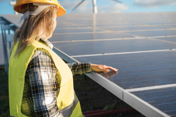 istock Engineer woman working at alternative energy farm - Focus on hand over solar panel 1340019782