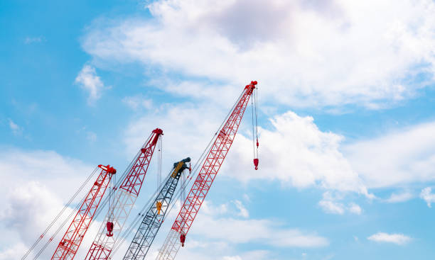 istock Crawler crane against blue sky and white clouds. Real estate industry. Red crawler crane use reel lift up equipment in construction site. Crane for rent. Crane dealership for construction business. 1340021992