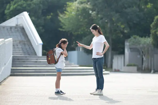 A woman scolding an elementary school student