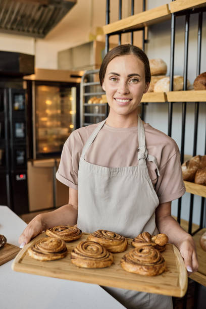 istock Happy female baker standing by workplace 1340025679