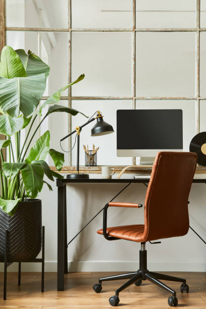 istock Creative workspace composition of modern masculine home office interior with black industrial desk, brown leather armchair, laptop, vintage record player and stylish personal accessories. Template. 1340028393