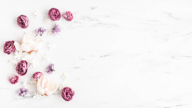 istock Flowers composition. White and purple flowers on marble background. Flat lay, top view 1340028737