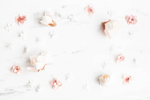 istock Flowers composition. White and pink flowers on marble background. Flat lay, top view 1340028742