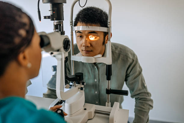 Doctor and patient in ophthalmology clinic Photo of female doctor ophthalmologist is checking the eye vision of young man in modern clinic. eye exam stock pictures, royalty-free photos & images