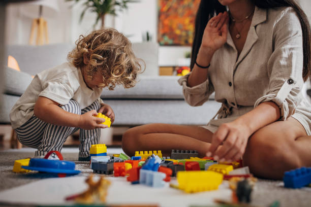 istock Little boy and mom playing with toy blocks 1340029142