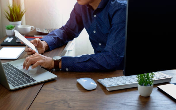 istock image of Businessman using and typing keyboard of laptop computer notebook on office desk. 1340032979