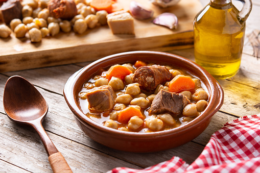 Traditional Spanish cocido madrileño. Chickpea stew on wooden table