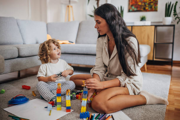 istock Little boy and mom playing with toy blocks 1340034162