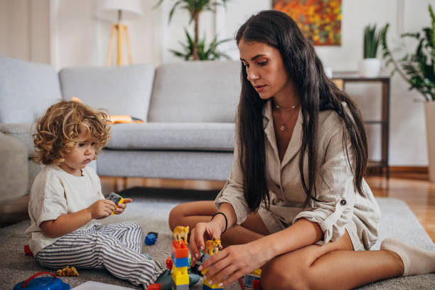 istock Little boy and mom playing with toy blocks 1340034832