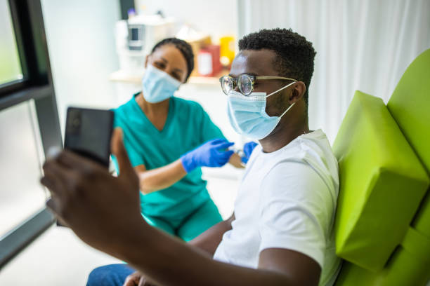 istock Young man taking a selfie while a nurse is vaccinating him against Covid-19 1340035073