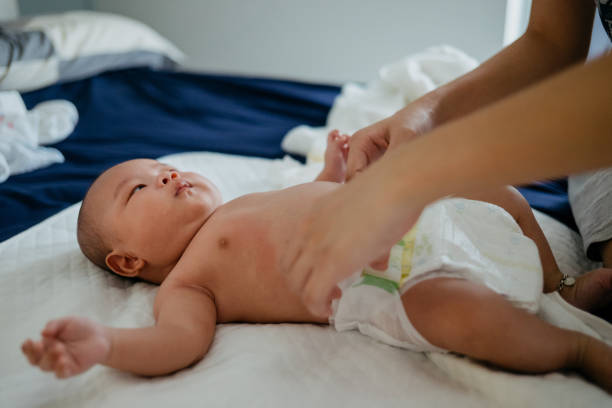 istock Asian mother changing diaper for her baby on bed 1340035300