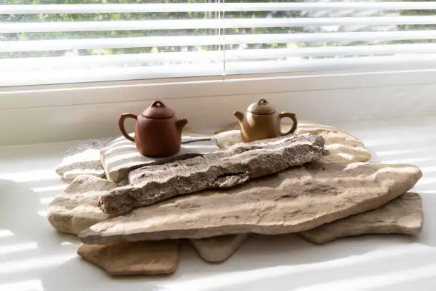 Photo of Asian teapots on the white windowsill. Tea ceremony