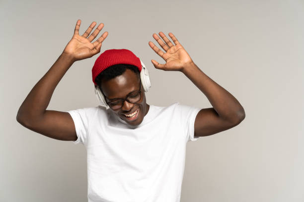 istock Cheerful Man Dancing While Listening Music Against Gray Background 1340039848