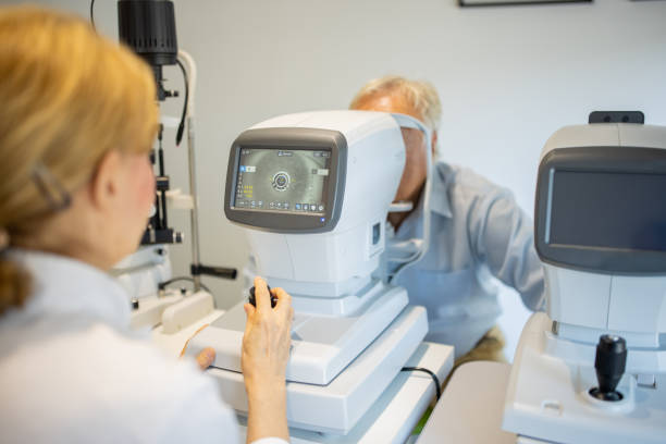 idoso fazendo exame oftalmologista no consultório do oftalmologista - patient senior adult optometrist eye exam - fotografias e filmes do acervo