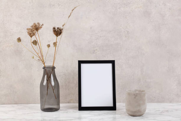 istock Empty picture frame and vase with dry flowers . Minimalist style home interior decoration. Simple and elegant design. Copy space image. 1340040737