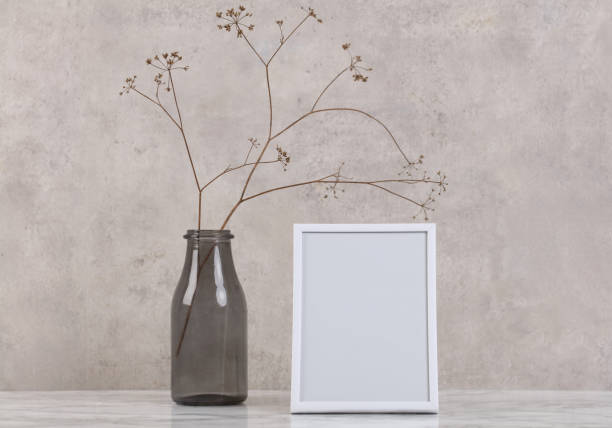 istock Empty picture frame and vase with dry flowers . Minimalist style home interior decoration. Simple and elegant design. Copy space image. 1340041345