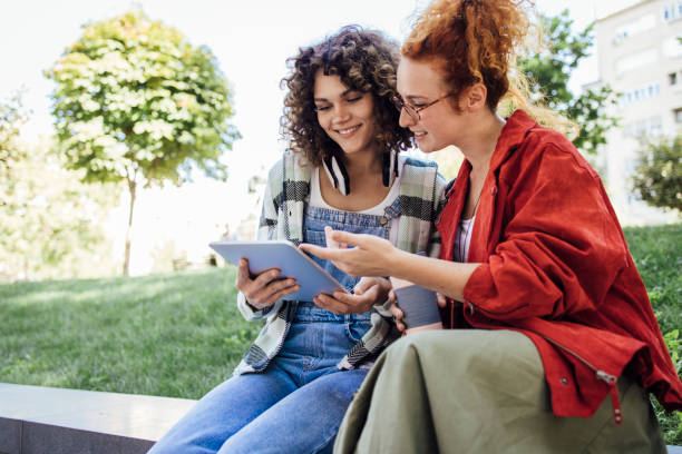istock Two friends using tablet and hanging out together 1340042848