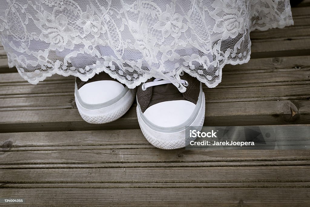 Bride wearing sneakers Ready for " Runaway bride". Bride wearing trainers and wedding dress. Sports Shoe Stock Photo