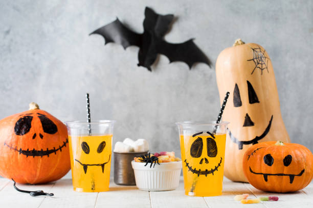 istock Drinks sweets and pumpkins with frightful faces on table 1340045143