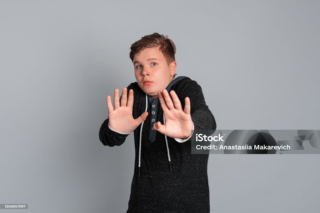 teen boy with scared facial expression can feel disgusted when they see things that make his sick, refusal or rejection concept teen boy with scared facial expression can feel disgusted when they see things that make his sick, refusal or rejection concept, isolated on grey background 14-15 Years Stock Photo