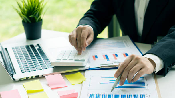 istock Businessman holding a pen pointing to an analysis graph, investment planning, work projects and business discussion strategies. 1340047314