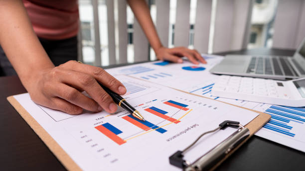 istock Businessman holding a pen pointing to an analysis graph, investment planning, work projects and business discussion strategies. 1340047358