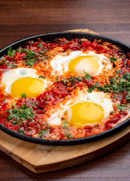 istock Scrambled eggs at home with tomatoes in a frying pan. On a wooden background. Breakfast 1340049512