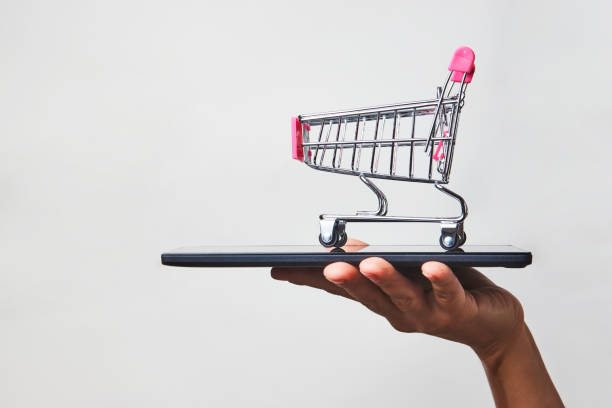 istock Woman hand with smartphone and trolley, close-up 1340049751