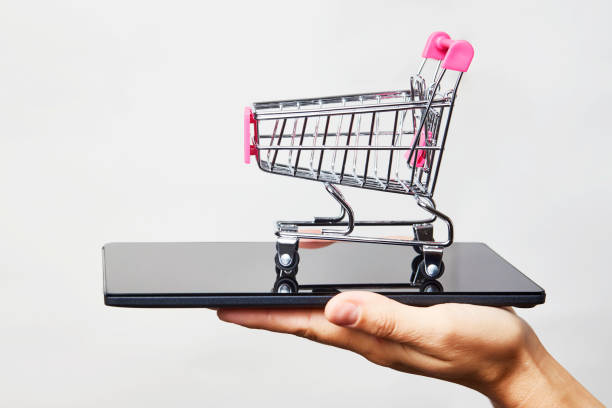 istock Woman hand with smartphone and trolley, close-up 1340049771