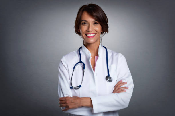istock Happy female doctor studio portrait while standing at isolated background 1340050666