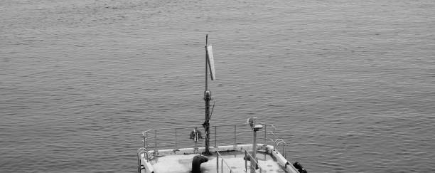istock Windsock on concrete dock piling pole near sea black and white banner 1340051525