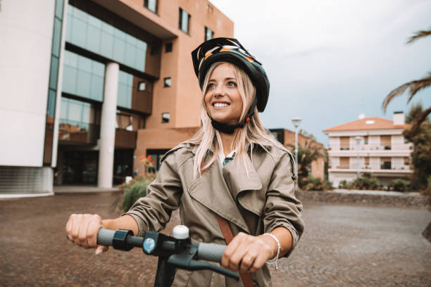 Woman commuting by e-scooter stock photo