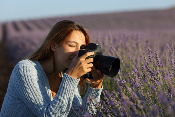 mujer fotografiando lavanda con cámara dslr en un campo - single lense reflex fotografías e imágenes de stock