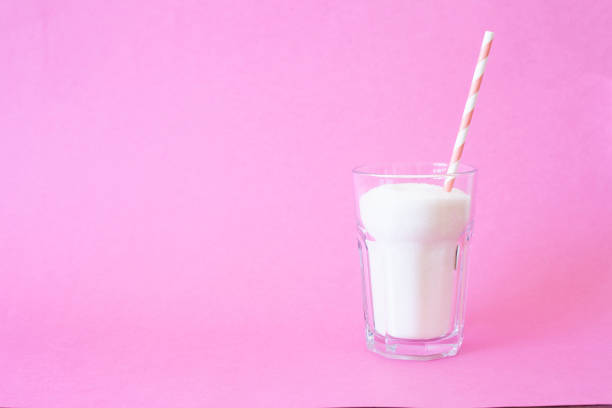 Cube sugar in glass on beautiful pink background - unhealthy diet concept.