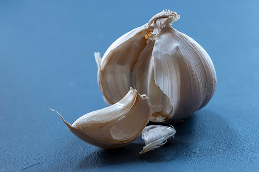 Close-up of garlic clove on blue background, selective focus, shot with a shift-tilt lens with natural light