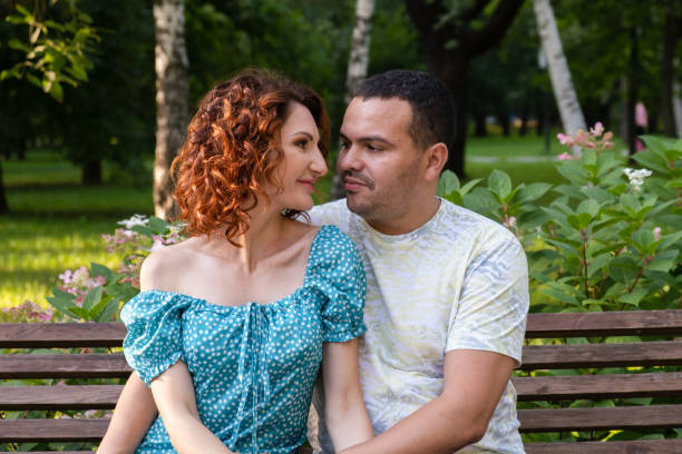 istock Loving couple on a park bench look at each other with tenderness 1340054285