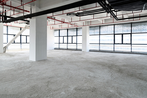 Interior of a modern office building with concrete walls and floor. Unfinished renovation