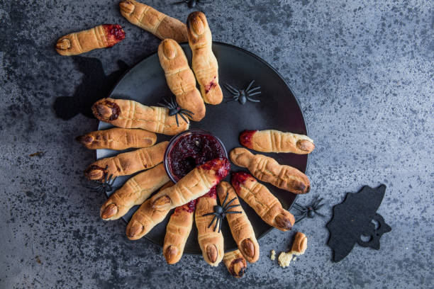 dedos de biscoitos sangrentos para a celebração da festa de halloween, biscoitos "dedos das bruxas". fundo escuro, comida para o halloween - witchs - fotografias e filmes do acervo