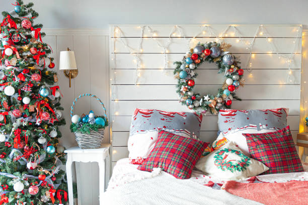istock Classic interior room with Christmas tree and traditional white red decorations. Modern clean white classical style interior design apartment bedroom. Christmas eve at home. Minimalist home design 1340055302