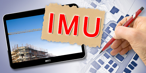 IMU (que significa Impuesto Municipal Único) el impuesto italiano más impopular sobre terrenos y edificios - Concepto con renderizado 3D de computadora portátil y edificio photo