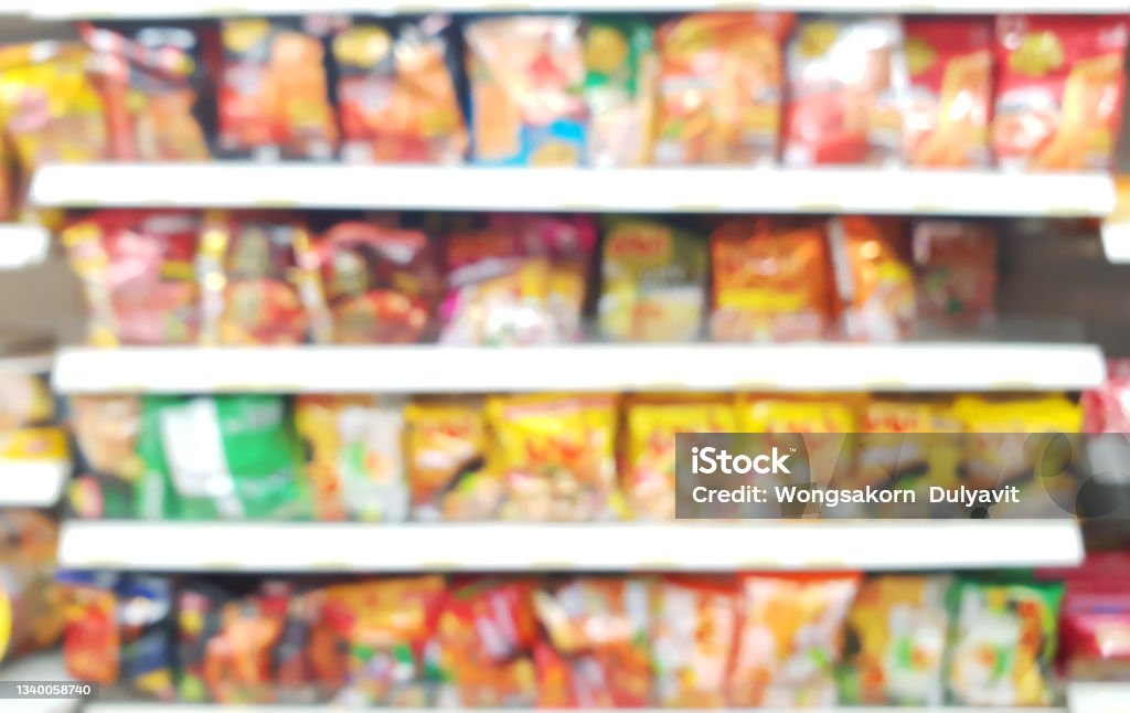 blurred view of assorted brand and type of instant noodles on shelf rack display in the convenience store. instant noodles brands on the shelf in supermarket for sell. Convenience Store Stock Photo