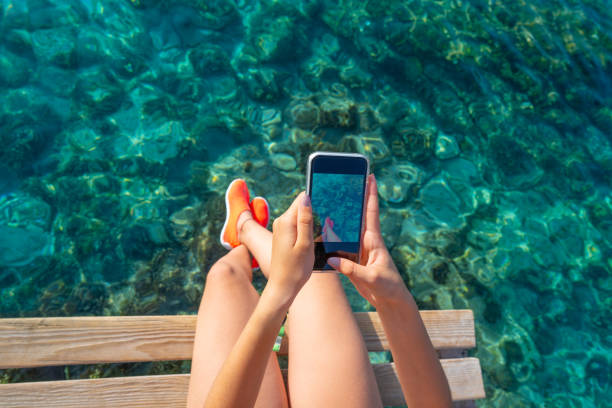 Ibiza girl taking smartphone photos stock photo